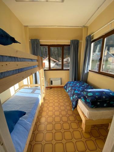 a bedroom with two bunk beds and windows at Lo Bec in Ronco Canavese