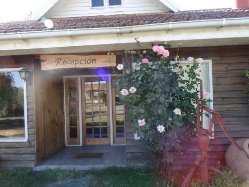 a building with a door with flowers on it at Cabañas Parque Salto del Laja in El Manzano