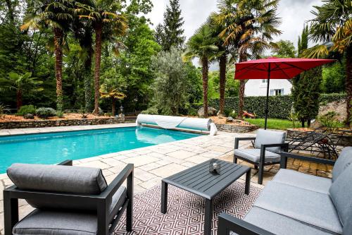 a patio with chairs and an umbrella next to a pool at Lodge ou Gîte de caractére avec jaccuzi spa piscine in Argelès-Gazost