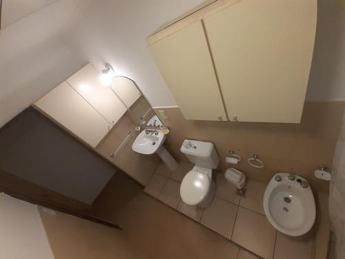 baño con aseo, lavabo y urinario en Sterlizia departamento en Olavarría
