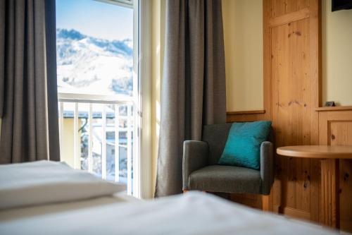 a room with a chair and a window with a view at Das Martell in Sankt Johann im Pongau