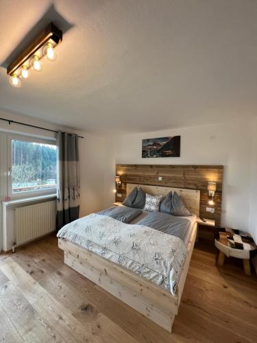 a bedroom with a large bed with a wooden headboard at Berghof Haselsberger in Sankt Johann in Tirol