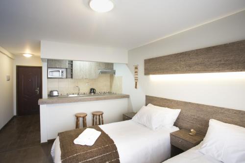 a hotel room with a bed and a kitchen at Rumbo Sur Apart Hotel in Coihaique