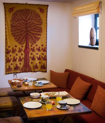 a living room with a table and a tree painting on the wall at Gaia Guesthouse in Dilofo