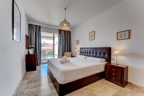 - une chambre avec un grand lit et une fenêtre dans l'établissement Modern apartment with large terrasse, bbq, fast wifi, 2 pools, à Puerto de Santiago