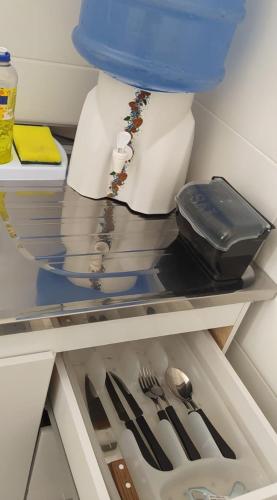 a refrigerator filled with silver utensils on a shelf at COMPLEJO PONTA das BRILLES. DTO. 2. in Barra de Tabatinga