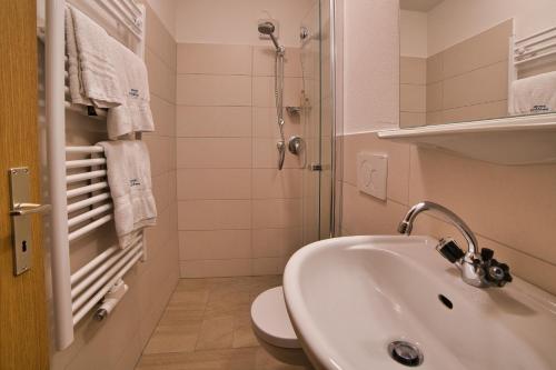 a bathroom with a sink and a toilet and a shower at Berghotel Franzenshöhe in Trafoi