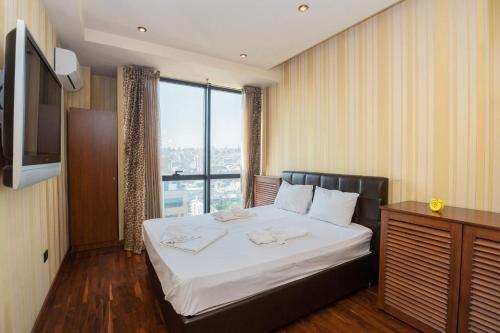 1 dormitorio con cama y ventana grande en Stay Inn-Ararat View apt near Vernissage, en Ereván