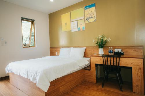 a bedroom with a bed and a desk with a chair at Ninh Binh The View Point Home & Spa in Ninh Binh