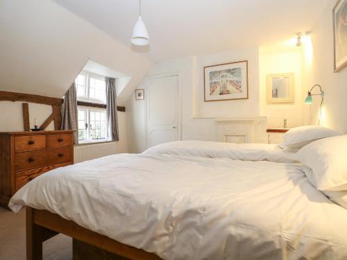 a bedroom with two beds and a dresser at 48 Polecat Cottages in Lewes