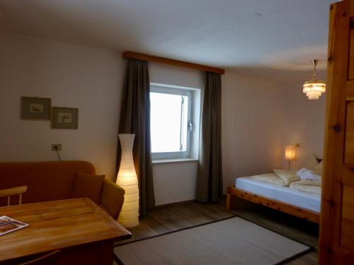 Habitación pequeña con cama y ventana en Berghotel Franzenshöhe, en Trafoi