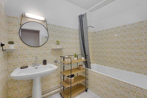 La salle de bains est pourvue d'un lavabo et d'un miroir. dans l'établissement BEL CANTO - Charmant appartement de 50 m2, à Toulouse