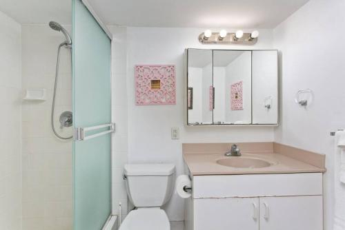 a bathroom with a toilet and a sink and a mirror at Ilikai Apt 1618 - Spacious 2BR 2BA Unit with Stunning Ocean-Lagoon View in Honolulu