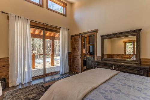 Un dormitorio con una cama y un espejo grande. en Hook Wine and Sinker at Eagles Nest, en Banner Elk