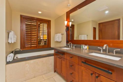 a bathroom with two sinks and a large mirror at Ko Olina Beach Villas B210 - Beach Front Luxury 2BR 2BA Condo with 1 Free Parking in Kapolei