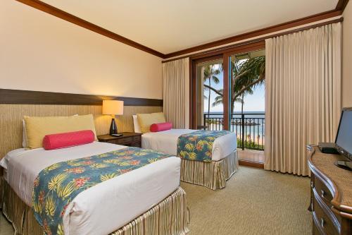 ein Hotelzimmer mit 2 Betten und einem Balkon in der Unterkunft Ko Olina Beach Villas B210 - Beach Front Luxury 2BR 2BA Condo with 1 Free Parking in Kapolei