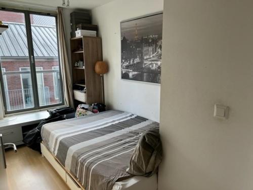 een slaapkamer met een bed in een kamer met ramen bij center appartement 2 rooms in Alphen aan den Rijn