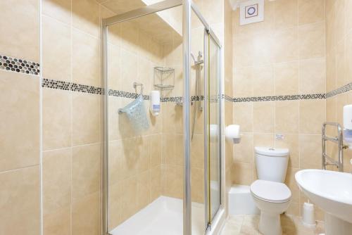 a bathroom with a shower and a toilet and a sink at Devonshire Hotel in Torquay