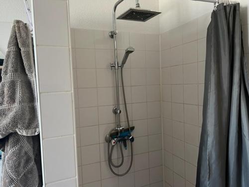 een douche in een badkamer met een douchegordijn bij center appartement 2 rooms in Alphen aan den Rijn