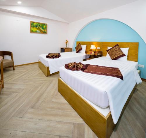 a hotel room with two beds and a table at Prime New Hotel in Nha Trang
