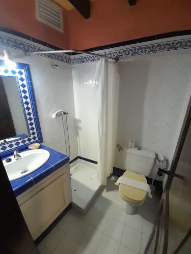 a bathroom with a sink and a toilet and a mirror at Navila Palmera in Ibiza Town
