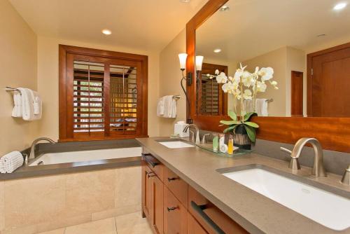 a bathroom with two sinks and a large mirror at Ko Olina Beach Villas B304 - 3BR Luxury Condo with Stunning Ocean View & 2 Free Parking in Kapolei