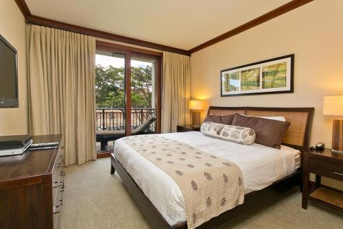 Schlafzimmer mit einem Bett, einem Schreibtisch und einem TV in der Unterkunft Ko Olina Beach Villas B304 - 3BR Luxury Condo with Stunning Ocean View & 2 Free Parking in Kapolei