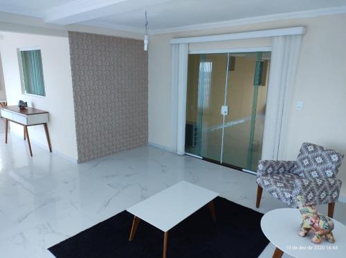 a living room with a chair and a table at CASA COM PISCINA À BEIRA MAR. in Recife