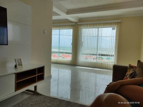 a living room with a couch and views of the ocean at CASA COM PISCINA À BEIRA MAR. in Recife