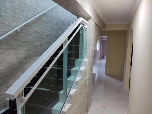 a glass staircase in a house with a brick wall at CASA COM PISCINA À BEIRA MAR. in Recife