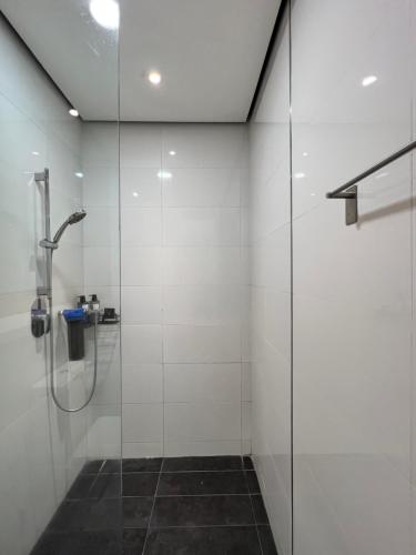 La salle de bains est pourvue d'une douche avec une porte en verre. dans l'établissement 1-4pax Modern Furnishing Arcoris-5 min to 163 mall, à Kuala Lumpur
