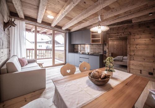 a kitchen and living room with a table and a couch at Ciasa Somuer - Sorà in San Vigilio Di Marebbe