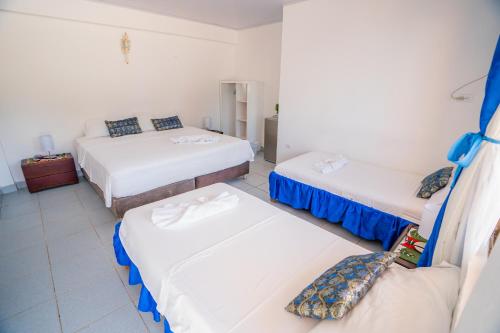a room with three beds and a couch in it at Hotel El Pirata Morgan in Providencia