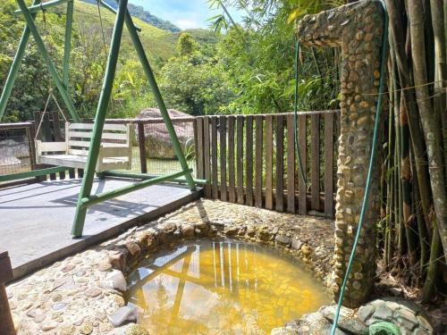 瑟拿的住宿－Sana - Aluguel Econômico，花园中的池塘,花园中设有木栅栏
