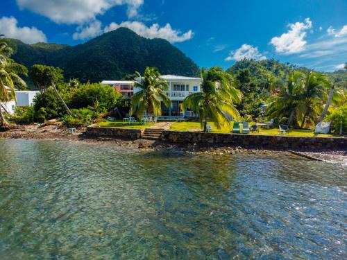 a house on the shore of a body of water at Hotel El Pirata Morgan in Providencia