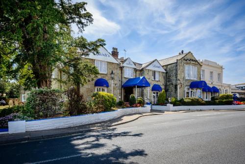 a building with blue umbrellas on the side of a street at Daish's Hotel in Shanklin