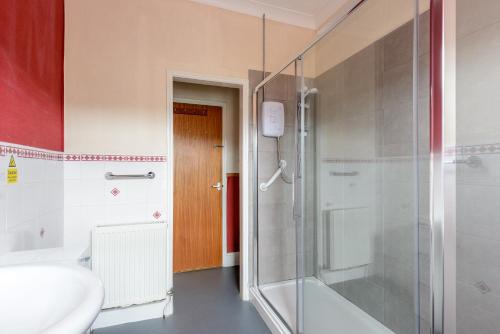 Un baño con ducha, inodoro y lavabo. en Daish's Hotel, en Shanklin
