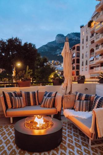 a patio with couches and a table with a fire pit at Columbus Hotel Monte-Carlo, Curio Collection by Hilton in Monte Carlo