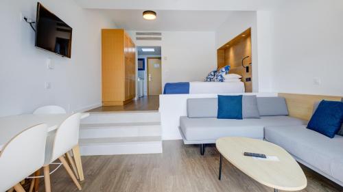 Playitas Aparthotel - Sports Resort في لاس بلايتاس: غرفة معيشة مع أريكة وسرير