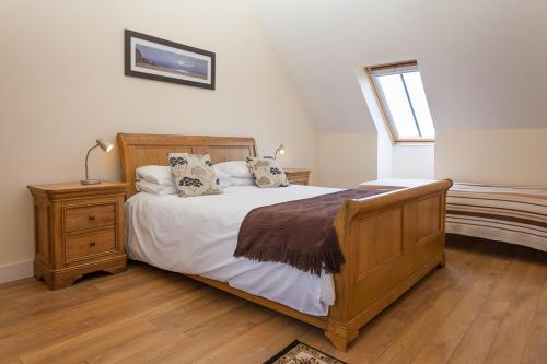 a bedroom with a wooden bed and a window at 1 Eden at Williamscraig Holiday Cottages in Linlithgow