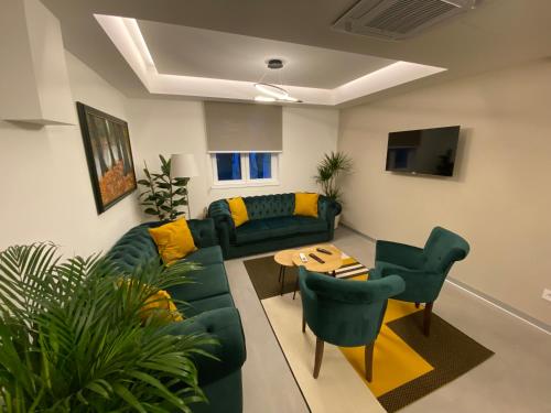 a living room with a green couch and chairs at Konak Stella in Belgrade