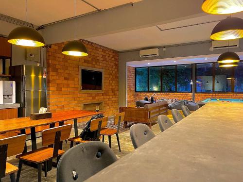 a restaurant with tables and chairs in a room at Arch Dormitorio Cenang in Pantai Cenang