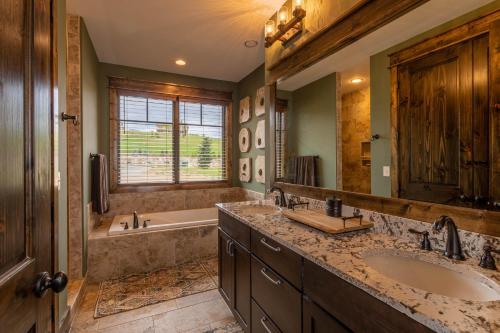 a bathroom with two sinks and a tub and a large mirror at Eagles Overlook at Eagles Nest in Elk Park