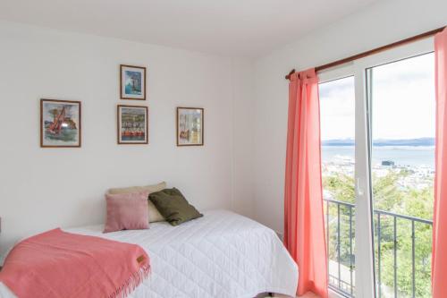 a bedroom with a bed and a large window at Gray Fox Apartments Alem in Ushuaia