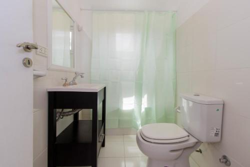 a white bathroom with a toilet and a sink at Gray Fox Apartments Alem in Ushuaia