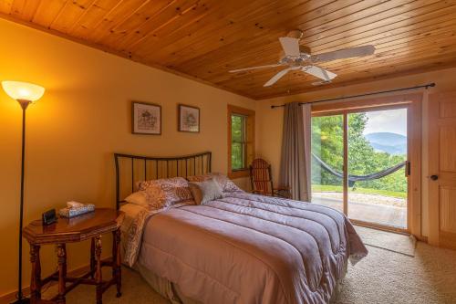 a bedroom with a bed with a ceiling fan and a window at 1 Relaxing Place in Todd