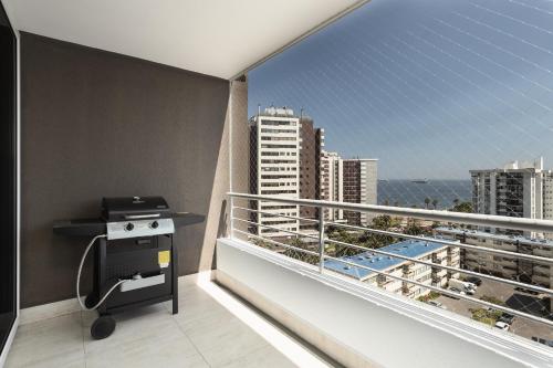 d'un balcon avec barbecue et vue sur l'océan. dans l'établissement departamento 9 norte 450, à Viña del Mar