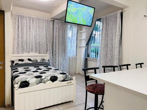 a bedroom with a bed and a television on a wall at New - Luxury Studio 3 Minutes From Beach ! in Tel Aviv