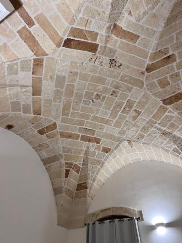 um tecto de tijolos num quarto com um candeeiro em Holiday House Signuria em Lecce