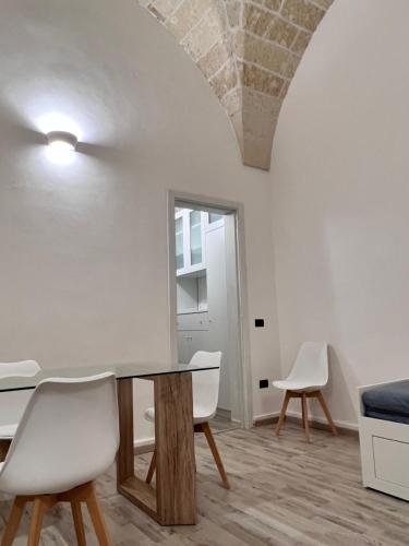 um quarto com uma mesa e duas cadeiras e um espelho em Holiday House Signuria em Lecce